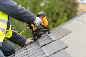 shingle installation on a roof with nail gun